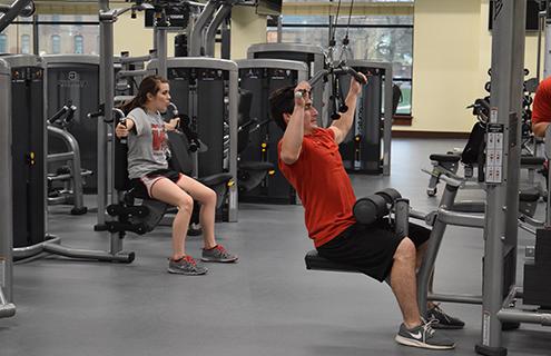 Students using weightlifting machines